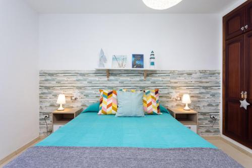 - une chambre avec un lit bleu et 2 tables de nuit dans l'établissement Home2Book Stunning Apartment Bajamar, à Bajamar