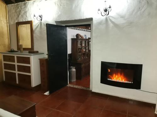 a living room with a fireplace in the wall at Casa La Gollada in Cazadores