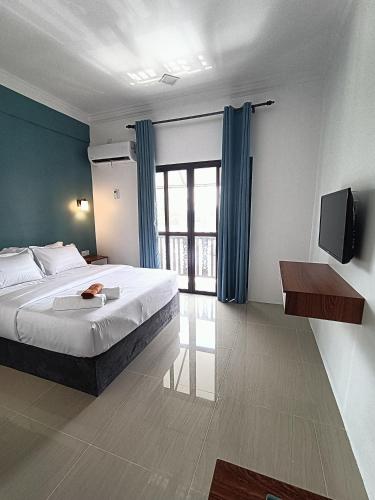 a bedroom with a bed and a television in it at VILLA WANIE INN in Setiu