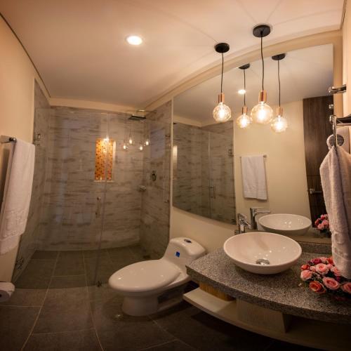 a bathroom with a toilet and a sink and a shower at Trugo Luxury Rooms in Armenia