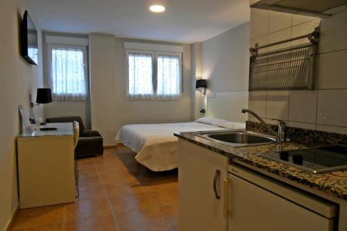 Habitación con cama y cocina con fregadero en Hostal El Estudio en Almansa