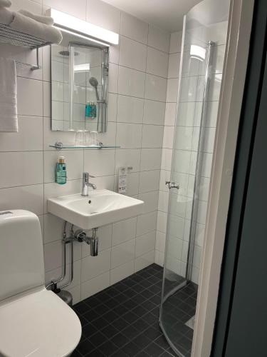 a white bathroom with a sink and a shower at Best Western Princess Hotel in Norrköping