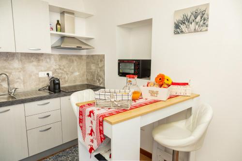 a kitchen with white cabinets and a table with fruit on it at Eutuxia in Taranto