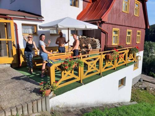 a group of people sitting on a porch of a house at Pension Paulů in Pec pod Sněžkou