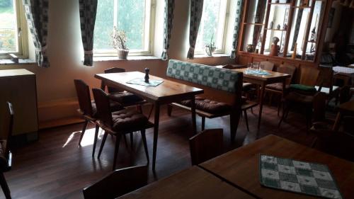a dining room with tables and chairs and windows at Pension Paulů in Pec pod Sněžkou