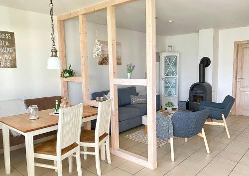 un salon avec une table et un canapé bleu dans l'établissement Hygge-skandinavisch-mit-Kamin-und-Sauna, à Sierksdorf