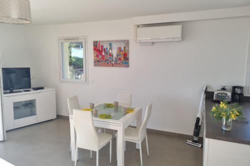 une cuisine et une salle à manger avec une table et des chaises blanches dans l'établissement Apt With Pool Magnificent Sea View 80m To Beach, à Sainte-Maxime