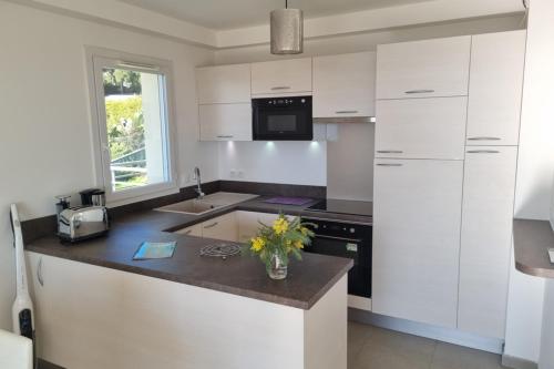 une cuisine avec des armoires blanches et un comptoir dans l'établissement Apt With Pool Magnificent Sea View 80m To Beach, à Sainte-Maxime