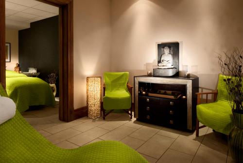 a room with green chairs and a bed and a mirror at Radisson Blu Hotel, Durham in Durham