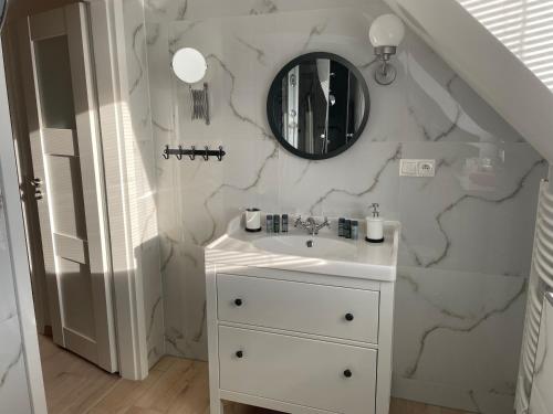 a bathroom with a sink and a mirror on a wall at Vila Alila in Stará Lesná