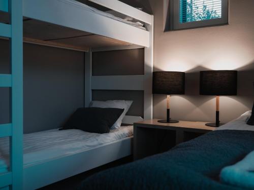 a bedroom with two bunk beds and a desk with two lamps at Levin Kunkku C 2 in Levi