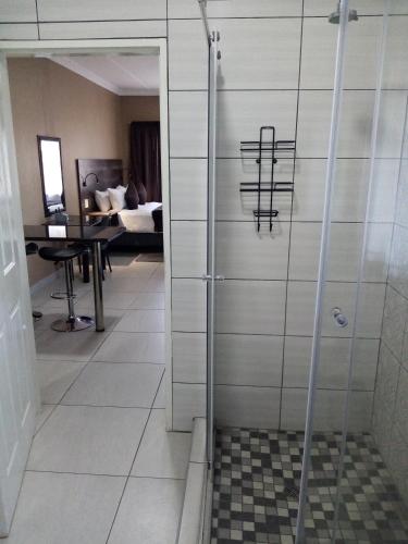 a shower with a glass door in a room at Casa Leitao Lodge in Phalaborwa