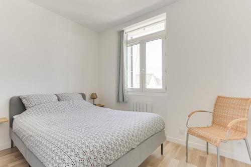 - une chambre blanche avec un lit et une chaise dans l'établissement cosy cottage proche gare, à Vannes