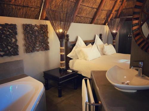 a bathroom with a bed and a sink and a tub at Little Eden Guest Lodge in Vanderbijlpark