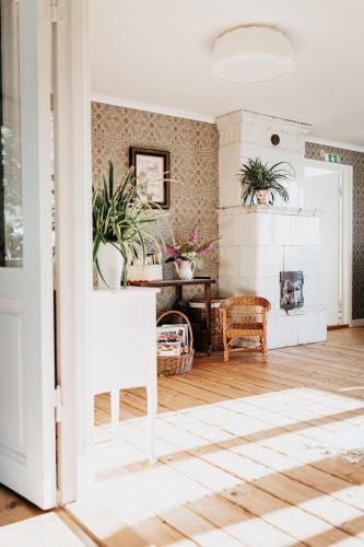 a living room with a fireplace and a table at Karlsberg Gård B&B in Tvååker