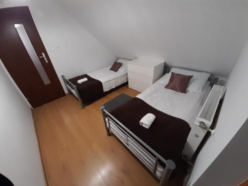 a small bedroom with two beds in a room at Sarzynówka in Krasnobród