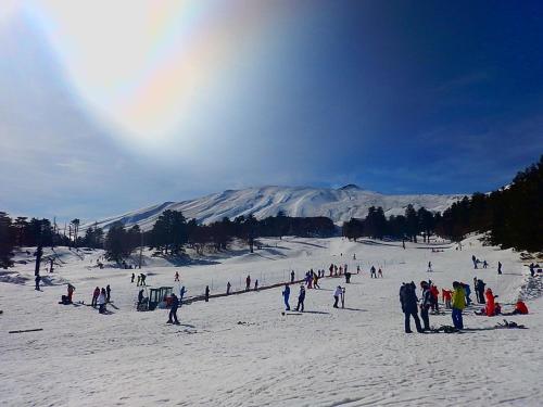 a group of people in the snow on a ski slope at La Pigna dell'Etna in Nicolosi