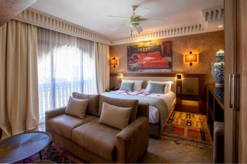 a hotel room with a bed and a couch at Les Jardins De La Koutoubia in Marrakech