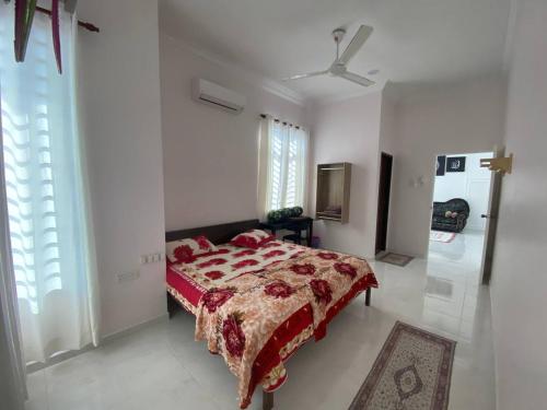 a bedroom with a bed and a ceiling fan at ADDA Guest House in Kota Bharu