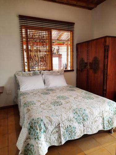 a bedroom with a bed and a window at FINCA HOTEL DON JULIO in Santa Rosa de Cabal