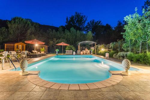 a swimming pool in a backyard at night at Le Bicocche Farmhouse: Country Stone Villa with Pool in Camaiore between Lucca & Beaches of Versilia in Montemagno