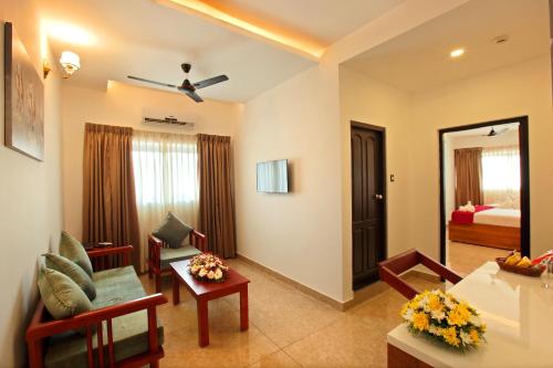 sala de estar con sofá y habitación con cama en Hotel Thamburu International, en Trivandrum