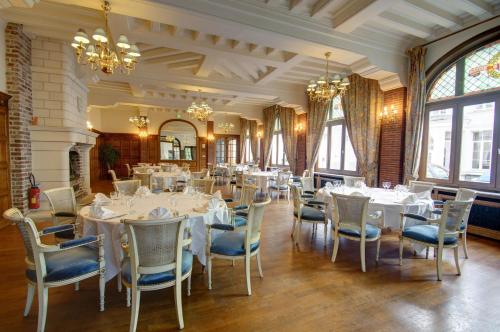 a dining room with white tables and chairs at Hôtel de L'univers in Arras