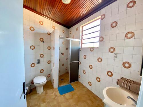 La salle de bains est pourvue de toilettes et d'un lavabo. dans l'établissement Pousada Casa de Bragança, à Bragança Paulista