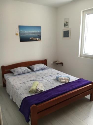 ein Schlafzimmer mit einem Bett mit zwei Kissen darauf in der Unterkunft APARTMENT ŽUŽI Otok Silba Hrvatska in Silba