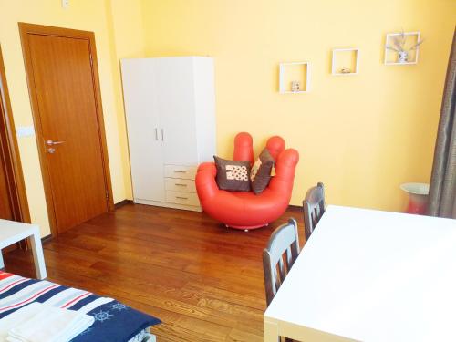 a living room with a red chair in the corner at Стаи за Гости Lavender Lozen in Lozen
