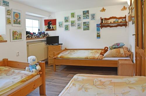 a bedroom with two beds and a teddy bear at Chalupa Mája in Hřensko