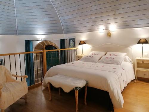 1 dormitorio con 1 cama blanca grande y 1 silla en Gîte Atypique Dans Une Chapelle en Briec