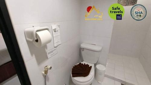 a bathroom with a toilet and a sign on the wall at Beach Home Lanta in Ko Lanta