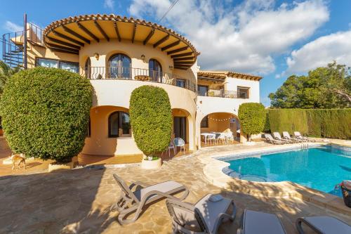 a villa with a swimming pool and a house at Villa Mandarina - Costa CarpeDiem in Calpe