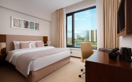 a hotel room with a bed and a desk and a window at Palmira Business Club in Moscow