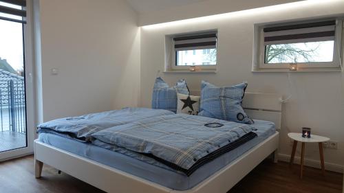 1 dormitorio con 1 cama con sábanas y almohadas azules en "GESTRANDET" in der Villa Katharina- en Dierhagen