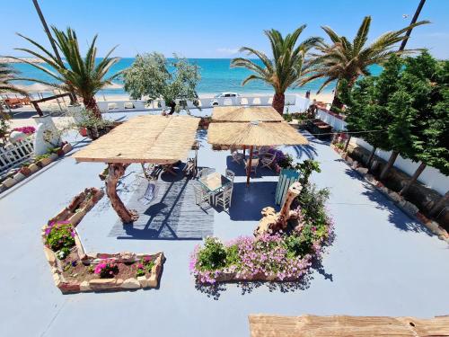 an aerial view of a beach with umbrellas and flowers at Votsalo Cozy Apartments in Limenaria