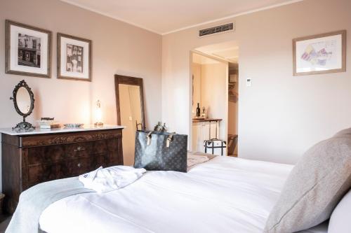 a bedroom with a white bed and a dresser at Domaine Rabiega - Vineyard and Boutique hotel in Draguignan