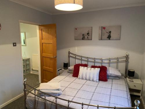 1 dormitorio con 1 cama con almohadas rojas y blancas en Palmbeach Place, en Kent