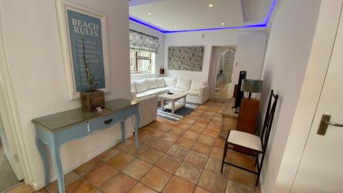 a living room with a table and a couch at Charming Sea Side Sun Apartment in Hermanus
