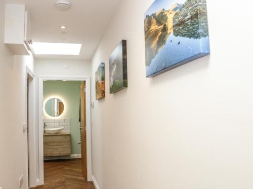 a hallway with paintings on the walls of a house at Y Bwthyn in Amlwch