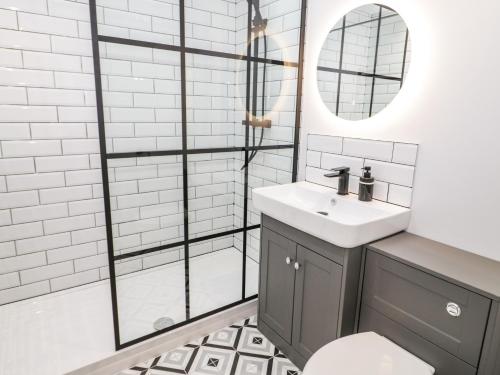 a bathroom with a sink and a mirror at Y Bwthyn in Amlwch