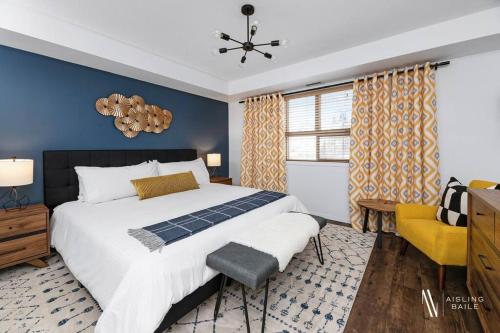 a bedroom with a large bed and a blue wall at Chic Retreat, Modern, Pool, Hot Tub, Gym in Invermere