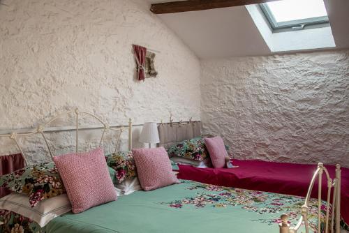 1 Schlafzimmer mit 2 Betten mit rosa und grüner Bettwäsche in der Unterkunft Rose Barn in Cersay