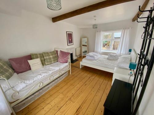 a living room with two beds and a window at Exmouth Country Lodge and Cottage in Exmouth