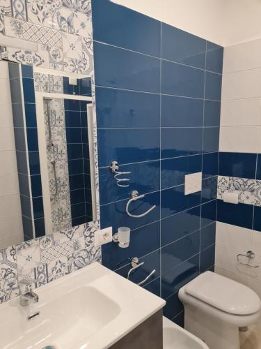 baño azul y blanco con aseo y lavamanos en B&B Rayl, en Formia