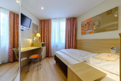 a hotel room with a bed and a desk at Hotel VICTORIA Nürnberg in Nürnberg