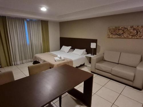 une chambre d'hôtel avec un lit, un canapé et une table dans l'établissement Happy Hotel Manaíra, à João Pessoa