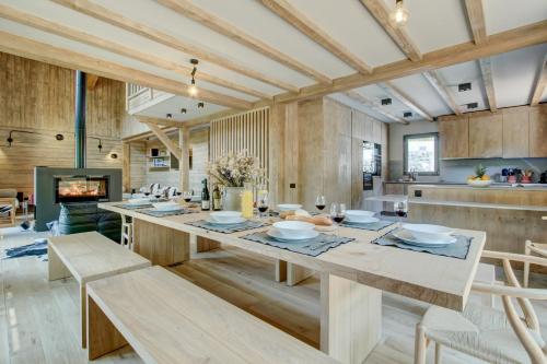 une cuisine avec une grande table et des chaises en bois dans l'établissement Chalet La Mésange Cendrée, à Morzine