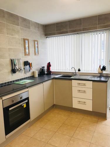 a kitchen with a sink and a stove at Towan Beach Holiday Flat in Newquay